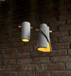 two lamps hanging from the ceiling next to a brick wall