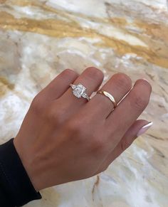 a woman's hand with two rings on it and one ring in the middle