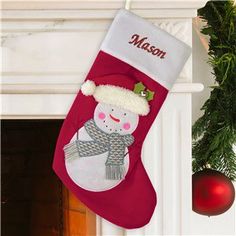 a christmas stocking with a snowman on it hanging from a fireplace mantel