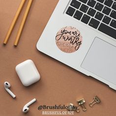 an apple airpods sitting on top of a desk next to ear buds and pencils