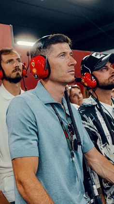 a group of men with red ear muffs on their heads in front of them