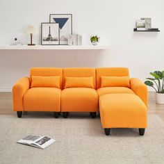 an orange sectional sofa sitting on top of a rug in front of a white wall