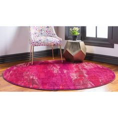 a bright pink rug in the corner of a room with a chair and potted plant