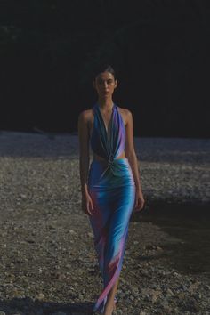 Introducing the "Odette Dress" in Interstellar – make a bold statement with this deep V-neck maxi dress that ties at the neck, featuring side cutouts and an open back. The Baobab shape embellishment creates a stunning ruched effect at the front, adding texture and enhancing the silhouette. Ideal for summer soirées or beachside dinners, this dress exudes elegance and allure. Odette Dress, Bleecker Street, Summer 24, Interstellar, Top Dress, Deep V Neck, Skirt Pants, Open Back, The Sea