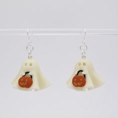 two white ghost earrings with red pumpkins on them