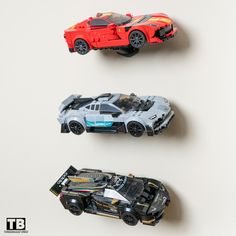 three toy cars are lined up on the wall