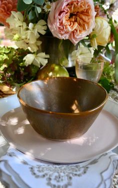 a table set with plates and flowers on it