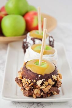 three desserts on a white plate with apples in the background