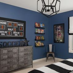 a bedroom with blue walls and black and white decor on the wall is decorated with sports memorabilia