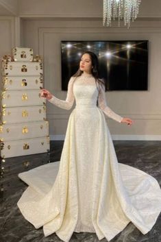 a woman in a white wedding dress posing for the camera with her arms outstretched and hands out