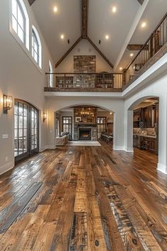 a large open floor plan with wood floors and high vaulted ceilings in an upscale home