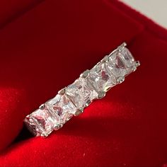 a diamond ring sitting on top of a red velvet cushion