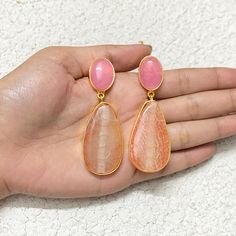 Pink Quartz and orange gemstone hanging earrings feature a stunning blend of colors, set in gold dangles.  With a modern yet classic design, these long drop earrings make a bold statement, perfect for weddings or special occasions. An elegant and thoughtful anniversary gift for her. *𝐏𝐑𝐎𝐃𝐔𝐂𝐓 𝐃𝐄𝐓𝐀𝐈𝐋* * 𝐌𝐚𝐭𝐞𝐫𝐢𝐚𝐥: Brass * 𝐏𝐥𝐚𝐭𝐢𝐧𝐠: Gold Plated * 𝐒𝐭𝐨𝐧𝐞: Rose Quartz & Aventurine. *𝐃𝐈𝐌𝐄𝐍𝐒𝐈𝐎𝐍𝐒* * 𝐖𝐞𝐢𝐠𝐡𝐭: 18 gm each * 𝐋𝐞𝐧𝐠𝐭𝐡: 2.5 Inches * 𝐖𝐢𝐝𝐭𝐡: Elegant Orange Chandelier Earrings Gift, Elegant Orange Chandelier Earrings For Gift, Orange Gemstone Dangle Earrings, Orange Gemstone Drop Earrings, Orange Teardrop Gemstone Earrings, Elegant Orange Earrings With Natural Stones, Orange Natural Stones Drop Earrings, Orange Natural Stone Drop Earrings, Fusion Style Gemstone Danglers Earrings