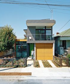 two story house with yellow garage door and balcony