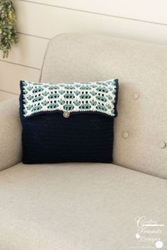 a blue and white pillow sitting on top of a gray couch next to a potted plant