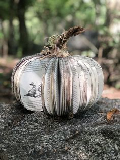 an open book pumpkin sitting on top of a rock