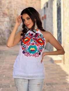 Be the star of the show with this one of a kind, embroidered Mexican Blouse. This Beautiful Floral Embroidered Halter Top is the perfect Top for Everyday use or a special event.  It is comfortable, made out of fine Mexican cotton and lace. It has a tie around the neck and elastic on the back for a comfortable fit. Available in sizes: S - 2X SHOP MORE BLOUSES HERE: https://www.etsy.com/es/shop/SoleiEthnic?ref=seller-platform-mcnav&section_id=25358815 Fitted Multicolor Embroidered Top With Intricate Embroidery, Fitted Multicolor Embroidered Top, Festive Intricate Embroidery Top, Bohemian Sleeveless Blouse With Intricate Embroidery, Bohemian Multicolor Embroidered Festive Top, Bohemian Sleeveless Top With Intricate Embroidery, Festival Cotton Embroidered Fabric, Multicolor Embroidered Folk Fabric, Bohemian Sleeveless Embroidered Top