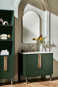 a bathroom with green cabinets and a white sink