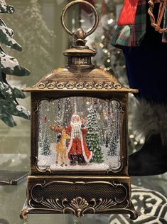 a christmas scene with santa claus and deer in a glass dome on a table next to a tree