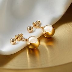 Gleaming 10mm white shell pearls on golden beads add just the right touch to your ensemble! The hanging length is 20mm (3/4"). The metal part is gold-plated and friendly to the skin. * Buy over 2 pieces and get a medium jewelry organizer* Buy over $100 and get a large mirror jewelry organizer Minimalism gold pearl earrings Take a look at our beautiful pearl earring design. These pearl drop earrings have been designed by a nature-originated jewelry designer and are made with faux pearls to give y Gold-plated Dangle Pearl Earrings, Gold Plated Gold Pearl Dangle Earrings, Gold-plated Gold Pearl Dangle Earrings, Gold Minimalist Pearl Earrings, Tarnish Resistant, Gold Minimalist Pearl Earrings Tarnish Resistant, Gold Pearl Earrings With Round Beads For Formal Occasions, Gold Minimalist Tarnish-resistant Pearl Earrings, Gold Pearl Bead Earrings For Formal Events, Gold Plated Tarnish Resistant Pearl Earrings