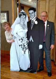 a bride and groom posing for a photo with their parents