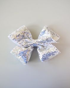 "Dress up any outfit with this large, sequined bow clip.  . 8\" x 6\" Bow  . Alligator Clip  We recommend spot cleaning this hairclip." Dance Bows, Large Sequins, Cheer Bow, Bow Clip, Sequin Bow, Silver Bow, Cheer Bows, Girls Gift, Silver Sequin