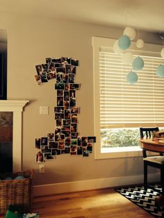 a number one made out of photos hanging on the wall next to a table and chair