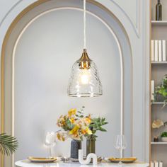 a dining room table with flowers and plates on it in front of an arched doorway