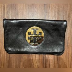 New Authentic Tory Burch Black Leather Clutch Evening Handbag Purse. Condition Is “New.” Item Comes From An Odor, Pet And Smoke Free Home. Brand: Tory Burch Color: Black Description: Tory Burch Leather Clutch With Gold Logo On The Front, Flat Design With Interior Double Zippered Compartment, And Chain Shoulder Strap. Never Used, In Great Condition! Make Me An Offer! All Reasonable Offers Will Be Considered. Black Clutch With Leather Lining For Formal Occasions, Formal Black Clutch With Leather Lining, Black Leather Clutch With Leather Lining, Designer Travel Clutch With Gold-tone Hardware, Designer Clutch With Leather Lining For Everyday Use, Designer Leather Clutch With Magnetic Closure, Elegant Black Clutch With Leather Lining, Designer Leather Clutch With Gold-tone Hardware, Designer Everyday Clutch With Magnetic Closure