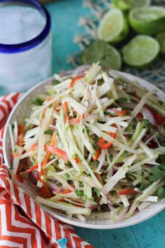 a white bowl filled with coleslaw and carrots on top of a blue table