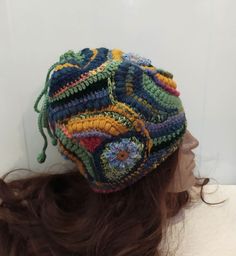 "A soft warm crochet  multicolor ( yellow, blue, green) Women  beanie hat  in boho style. This hat  made in a unique pattern that cannot be repeated exactly. Perhaps an approximate repetition.  This is a flight of fantasy and intuitive knitting. In this knitted set you will be unique, irresistible and delightful. This hat has no seam and you can turn it in any way and change your look.   This Beanie is sure to be the perfect accessory for your fall and winter wardrobe. It is stylish, functional, Yellow Yarn Crochet Hat, Yellow Crochet Cap Hat, Hand Knitted Multicolor Crochet Hat, Hand Knitted Multicolor Crochet Hat In Yarn, Yellow Crochet Yarn Cap, Yellow Yarn Crochet Cap, Adjustable Multicolor Whimsical Crochet Hat, Multicolor Hand Knitted Crochet Hat, Multicolor Hand-knitted Bohemian Crochet Hat