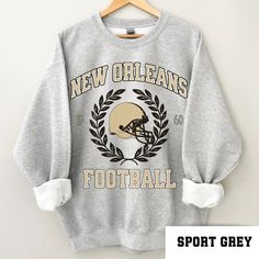 Perfect sweatshirt for New Orleans football fans this season! Ideal for any situation, a unisex heavy blend crewneck sweatshirt is pure comfort. These garments are made from polyester and cotton. This combination helps designs come out looking fresh and beautiful. The collar is ribbed knit, so it retains its shape even after washing. There are no itchy side seams on these sweaters.  .: 50% cotton, 50% polyester .: Medium-heavy fabric (8.0 oz/yd² (271.25 g/m .: Loose fit .: Sewn-in label .: Runs Fleece Sweatshirt Fan Apparel, Fan Apparel Crew Neck Hoodie, Fleece Fan Apparel Sweatshirt, Collegiate Crew Sweatshirt, Pre-shrunk, Collegiate Crew Sweatshirt Pre-shrunk, Athletic Heather Fan Apparel Sweatshirt For Sports Season, Sports Fan Crew Neck Sweatshirt, Sports Fan Sweatshirt With Crew Neck, Pre-shrunk, Sports Fan Sweatshirt With Crew Neck