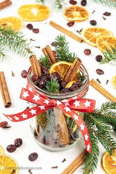 a jar filled with orange slices and cinnamon sticks