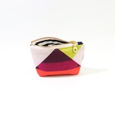 Introducing the Geometric Poofy Coin Pouch: a delightful blend of charm and versatility. This unique pouch combines a playful pink geometric pattern on one side with durable navy dry oilskin on the other, offering a stylish contrast that stands out. Measuring approximately 3.5" x 5" with a poofy, 1" gusseted design, this pouch not only holds your coins and small essentials but also stands on its own for easy access. The brass-colored metal zipper ensures secure closure, while adding a touch of vintage elegance to its modern design. Whether slipped into a purse or carried solo, the Geometric Poofy Coin Pouch is perfect for adding a pop of color and personality to your everyday carry. It's an ideal accessory for those who appreciate practicality without compromising on style. Modern Pouch With Coin Pocket For Everyday Use, Modern Coin Purse With Removable Pouch, Modern Compact Coin Purse For Personal Use, Modern Compact Coin Purse, Modern Compact Wallets With Zipper Pouch, Compact Modern Coin Purse, Modern Pouch With Coin Pocket For Daily Use, Modern Zipper Coin Purse For Personal Use, Modern Coin Purse With Zipper Pouch For Personal Use