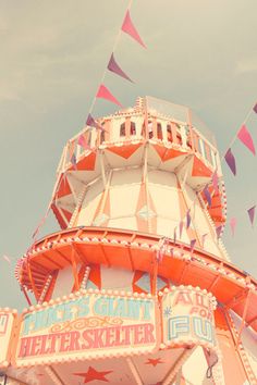 an amusement park ride with flags flying in the air