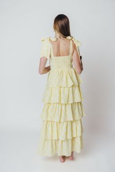 A stunning silhouette paired with summer-ready seersucker - the Jacquelyn Midi Dress has it all! This lovely gown is constructed from a textured, lightweight seersucker fabric in a playful plaid print, and features a sweetheart neckline, bustier bodice, and multi-tiered ruffle skirt. Pair with dainty heels for your next special event! FIT: Runs true to size. Bustier bodice is fitted, with a defined bust. MATERIAL: Hand wash cold, do not bleach. Line dry, do not tumble dry. Iron low if needed. GARMENT DETAILS: Plaid seersucker midi dress, with sweetheart neckline and bow-tie shoulder straps. Features a structured bustier-style bodice with defined bra, and a full skirt with multiple flounced tiers. SIZE GUIDE: S (2-4) / M (6-8) / L (10-12) MODEL DETAILS: Mackenzie - Size S Heather - Size S M Dainty Heels, Dress With Sweetheart Neckline, Seersucker Fabric, Garment Details, Curve Model, Tiered Ruffle Skirt, Yellow Plaid, Summer Ready, Ruffle Skirt