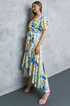 This maxi dress offers an elegant and flattering silhouette with a surplice neckline, flutter sleeves, and a self-tie sash. Its faux wrap design, with a ruffled edge, will ensure your look stands out. Crafted with a lightweight woven fabric, the BEST SHOT WOVEN MAXI DRESS will keep you cool and comfortable in any climate. Details Self: 100% Polyester Lining: 100% Polyester Size & Fit - Model is 5`8 " And Wearing Size Small - Measurements Taken From Size Small - Approx. Length: 58" Surplice Neckline Maxi Dress With Tie Waist For Vacation, Spring Flowy Faux Wrap Maxi Dress, Flowy Belted Wrap Dress With Surplice Neckline, Flowy Belted Maxi Dress With V-neck, Flowy Belted V-neck Maxi Dress, Flowy Midi-length Wrap Dress With Tie Waist, Flowy V-neck Belted Maxi Dress, Flowy Belted Maxi Length Wrap Dress, Belted Beach Dress With Surplice Neckline