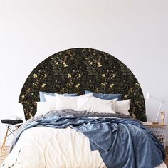 a bed with blue and white comforter on it's headboard in a bedroom