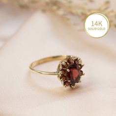 Elegant Garnet Flower ring in 14k yellow gold, multi stone halo engagement, wedding or promise ring for women.   This beautiful handmade ring is made of solid 14k yellow gold and is set with a faceted oval garnet, surrounded by a halo of 10 faceted smaller round garnets. The deep red of the gemstones combined with the classic halo design give this ring a regal look that cannot be ignored.   Garnet is January's birthstone.  This ring can be a wonderful engagement/promise/wedding ring, or a gift f 14k Gold Birthstone Cluster Ring, Classic Red Ruby Cluster Ring, Classic Red Cluster Ruby Ring, Fine Jewelry Garnet Cluster Ring, Fine Jewelry Round Cluster Ring With Garnet, Yellow Gold Garnet Jewelry With Round Cut, Red Ruby Ring With 17 Jewels In Round Cut, Anniversary Red Cluster Ring Stamped 14k, 14k Gold Cluster Rings For Gifts