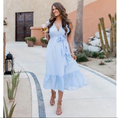 This Adorable Light Blue Dress Is Made For Days Out On The Town! We Love The Sweet Surplice Style And Ruffles From The Bodice To The Sleeves It's Such A Cute Detail. It Also Features A Midi Length, Tie Waist Style, And Lightweight Fabric. From Afternoon Parties To Vacations You're Sure To Love This Cute Dress. 100% Cotton Hand Wash Cold/Hang Dry Lined 100% Rayon Size Info Fabric Has No Stretch Length From Shoulder To Hem (On Hanger): L - 47.5" Bust: L - 39" How To Style Blue Dress, Taupe Dress, Orange Midi Dress, Navy Blue Midi Dress, Light Blue Dress, Cheetah Dress, Midi Wrap Dress, Light Blue Dresses, Belted Midi Dress