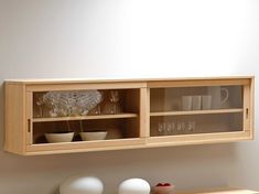 a wooden shelf with two glass shelves above it and vases on the counter top