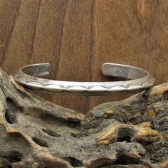 "Vintage sterling silver Native American cuff bracelet. The inside of the cuff measures 5 3/8\", the gap is 1\". The bracelet is approximately 1/4\" wide. There is a nice and simple stamp design. This cuff has a slight dimensional aspect to it as it tapers to a point along the center. Please feel free to message us with any questions. Thank you for shopping with us." Sterling Silver Cuff Bracelet Native American, Stamped Sterling Silver Cuff Bracelet, Sterling Silver Stamped Cuff Bangle, Classic Stamped Cuff Bracelets, Classic Stamped Cuff Bracelet, Classic Stamped Adjustable Cuff Bracelet, Classic Adjustable Stamped Cuff Bracelet, Sterling Silver Cuff Bracelet, Sterling Silver Cuff