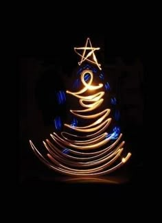 a christmas tree made out of lights in the dark with a star on it's top