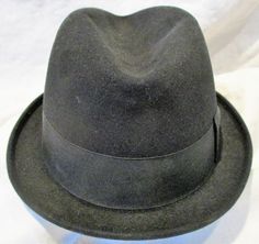 "I don't know anything about hats, so what I'm about to describe to you will be a challenge for me. Please bear with me, and if you see egregious errors or can enlighten me, I'd sure appreciate learning from the experts on Etsy! This appears to me to be a men's hat, 100% felted wool in a luxurious black color and the hat is marked \"KENWORTH\" and \"Imperial Finish\". It looks like a classic fedora hat, and has that wonderful mid century retro look. Nice ribbon detail and muted red and deep blue Formal Winter Cap Hat, Winter Formal Cap Hat, Formal Winter Cap, Vintage Fedora Felt Hat, Vintage Fedora Hat, One Size Fits Most, Vintage Fedora With Curved Brim, Fitted Vintage Cap, Vintage Brimmed Top Hat, Vintage Short Brim Top Hat