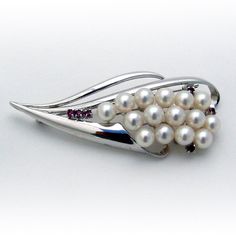 "Vintage sterling silver brooch, decorated with Akoya Pearl cluster and accented with Rubies. This elegant brooch is 2 3/4\" long, 1 1/8\" wide and weighs 14.7 grams; Pearls are 6.5-7 mm in diameter. EA1876" Collectible White Gold Brooch Jewelry, Collectible White Gold Brooch, White Gold Sterling Silver Brooches For Wedding, Wedding Brooches In White Gold And Sterling Silver, White Gold Sterling Silver Wedding Brooches, Sterling Silver Brooch With 17 Jewels For Formal Occasions, Formal Sterling Silver Brooch Jewelry, Formal Sterling Silver Brooch, Formal Sterling Silver Pendant Brooch