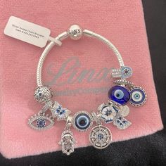 Linx Snake Chain Style Charm Bracelet In 925 Sterling Silver, With A Ball Clasp. The Bracelet Is 3mm In Width And Available In Multiple Lengths. This Bracelet Comes With 11 Linx 925 Sterling Silver Charms. All Items Are New And Come In A Luxury Velvet Jewelry Pouch. *Excellent Quality! Pandora Evil Eye Charm, Blue Jewelry With Dangling Charms, Blue Charm Bracelet With Dangling Charms As Gift, Nickel-free Blue Sterling Silver Bracelet As A Gift, Sterling Silver Evil Eye Bracelet In Silver, Blue Charm Bracelet Jewelry, Nickel-free Blue Sterling Silver Charm Bracelet, Silver Evil Eye Bracelets In Sterling Silver, Silver Evil Eye Bangle Bracelet For Gift