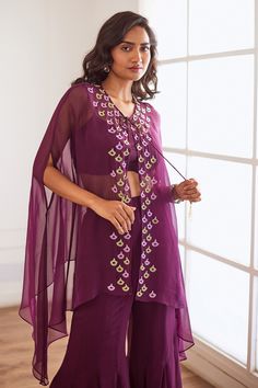 Wine sheer cape with crystal embellished floral motif border. Comes with crop top and sharara.
Components: 3
Pattern: Embroidered
Type Of Work: Cutdana,Sequin,Pearl
Neckline: Cape: Tie-up, Crop top: U-neck
Sleeve Type: Cape: Cape sleeves, Crop top: Sleeveless
Fabric: Semi Raw Silk, Georgette, Viscose Organza, Lining: Shantoon
Color: Wine
Other Details: 
Attached lining
Closure:
Cape: Front drawstring
Crop Top: Back hook
Sharara: Side zip
Occasion: Cocktail,Sangeet - Aza Fashions Front Open Resham Embroidered Georgette Sets, Front Open Georgette Sets With Resham Embroidery, Traditional Front Open Embellished Sets, Traditional Embellished Front Open Sets, Bohemian Party Sets With Cape Sleeves, Bohemian Palazzo Set With Cape Sleeves For Festive Occasions, Festive Embellished Front Open Sets, Traditional Front Open Palazzo Set For Party, Traditional Festive Palazzo Set With Cape Sleeves