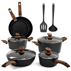 a set of pots and pans with wooden spoons next to each other on a white background