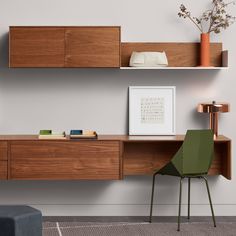 a living room with two shelves and a green chair in front of the shelf on the wall