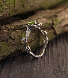 This silver engagement ring has a character all its own. A thin twig with leaves grows freely as it wants. And the peridot, as green as spring grass, is caught in the clutches of the twigs. This unique ring is the perfect gift for a wild forest fairy. Green Proposal Ring, Bug Engagement Rings, Forest Engagement Rings, Plant Engagement Ring, Silver Unique Wedding Rings, Earthy Wedding Rings Silver, Green Silver Ring, Woodland Engagement Ring, Green Stone Wedding Ring